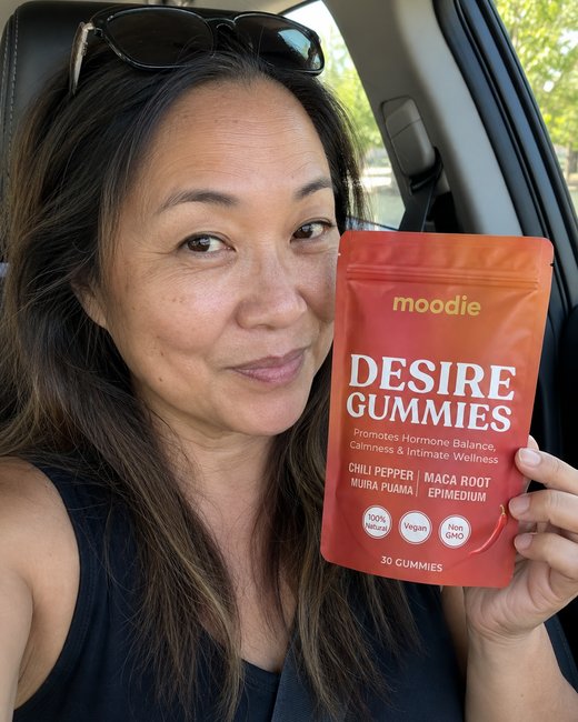 Moodie customer, 55, in the car, holding her pouch of Desire Gummies