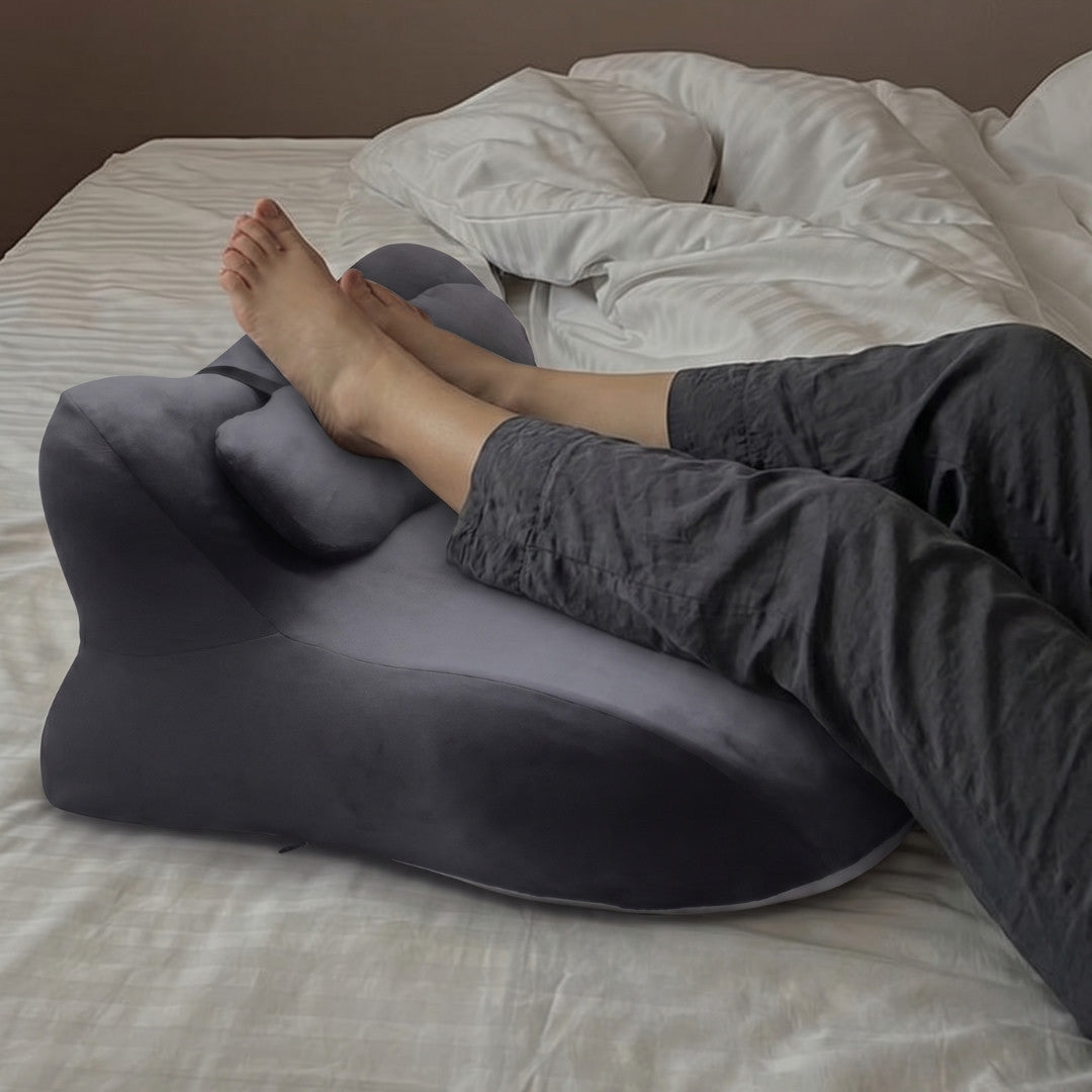 Moodie Pillow on a bed, legs resting over the wedge