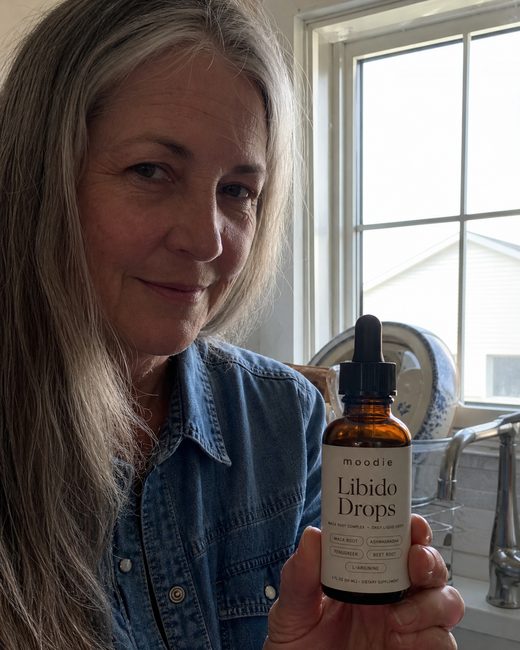 Moodie customer, 59, farmhouse kitchen, holding her bottle of Libido Drops